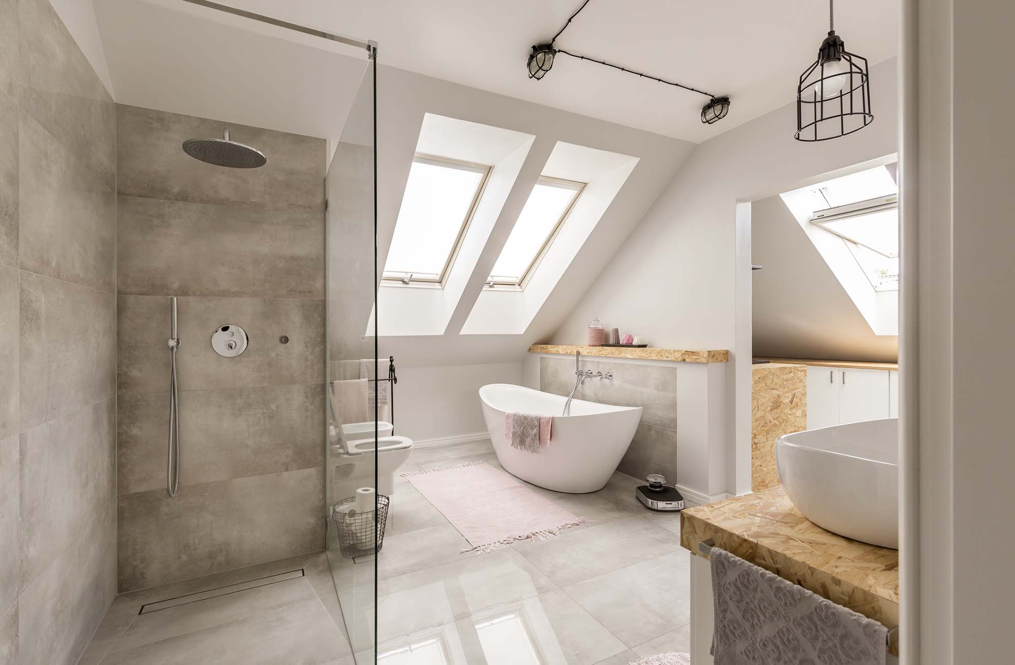 Modern bathroom interior with minimalistic shower and lighting, white toilet, sink, bathtub and roofwindows